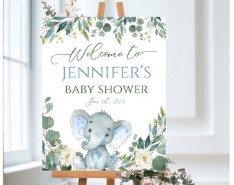 May include: Welcome to Jennifer's Baby Shower sign with a blue and gray elephant illustration, green leaves, and white flowers. The date June 1st, 2019 is printed on the sign.