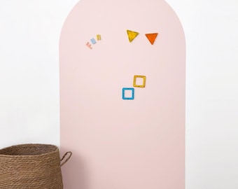 May include: A light pink arched wall with colorful geometric shapes and the word "FUN" in pink letters. The shapes include yellow and orange triangles, and blue and yellow squares. A woven basket is in the lower left corner.