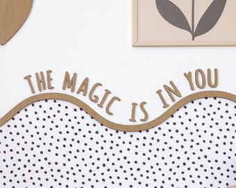 May include: Wooden letters spelling "The magic is in you" are arranged in a wave shape on a white background with black polka dots.