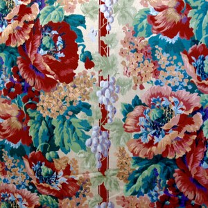 May include: A vintage floral fabric with a repeating pattern of red, pink, and blue flowers with green leaves on a cream background. The fabric has a vertical stripe of red and white.