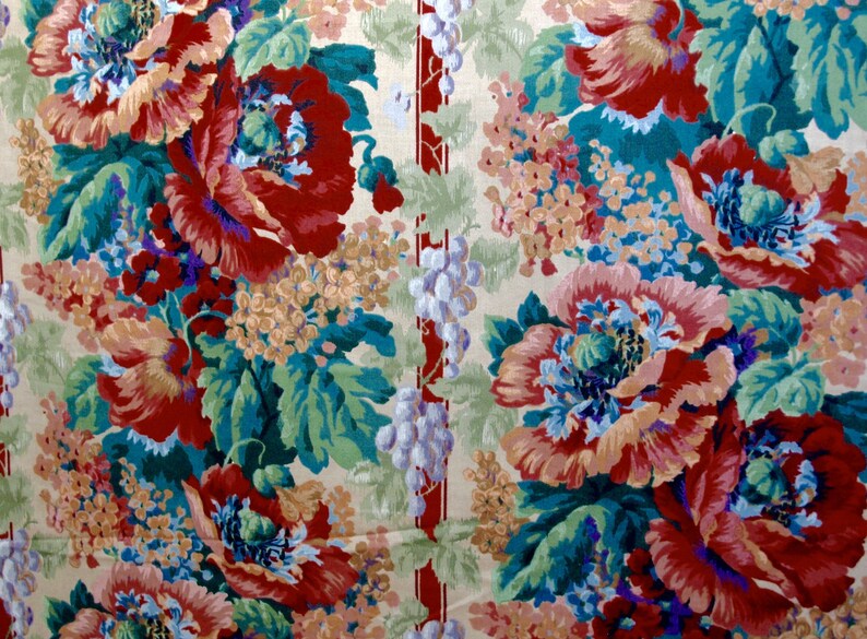 May include: A vintage floral fabric with a repeating pattern of red, pink, and blue flowers with green leaves on a cream background. The fabric has a vertical stripe of red and white.