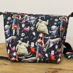 Puede incluir: Bolso de mano negro y blanco con tem&aacute;tica de Pesadilla Antes de Navidad con una variedad de personajes que incluyen a Jack Skellington, Sally y Oogie Boogie.