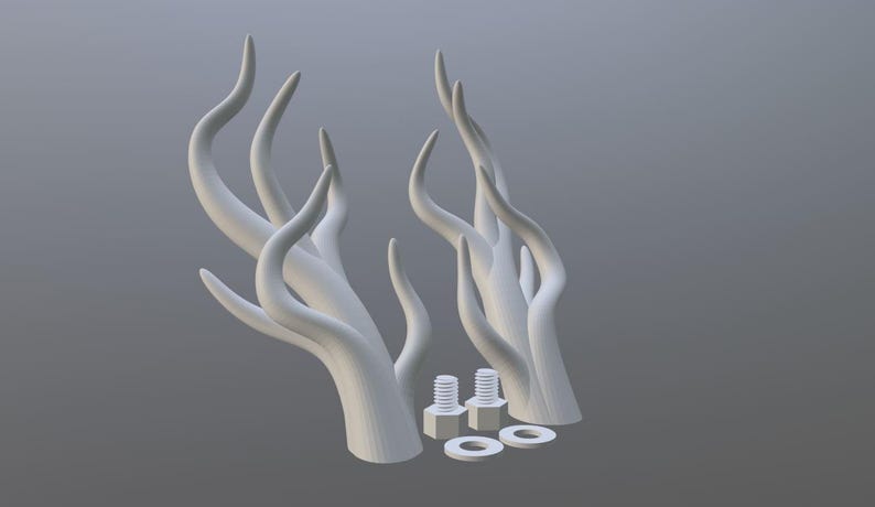 Peut inclure: Deux sculptures blanches abstraites en forme de cornes, avec des formes courbes et allong&eacute;es. L'image pr&eacute;sente &eacute;galement deux boulons et deux rondelles. Les objets sont pos&eacute;s sur un fond gris.