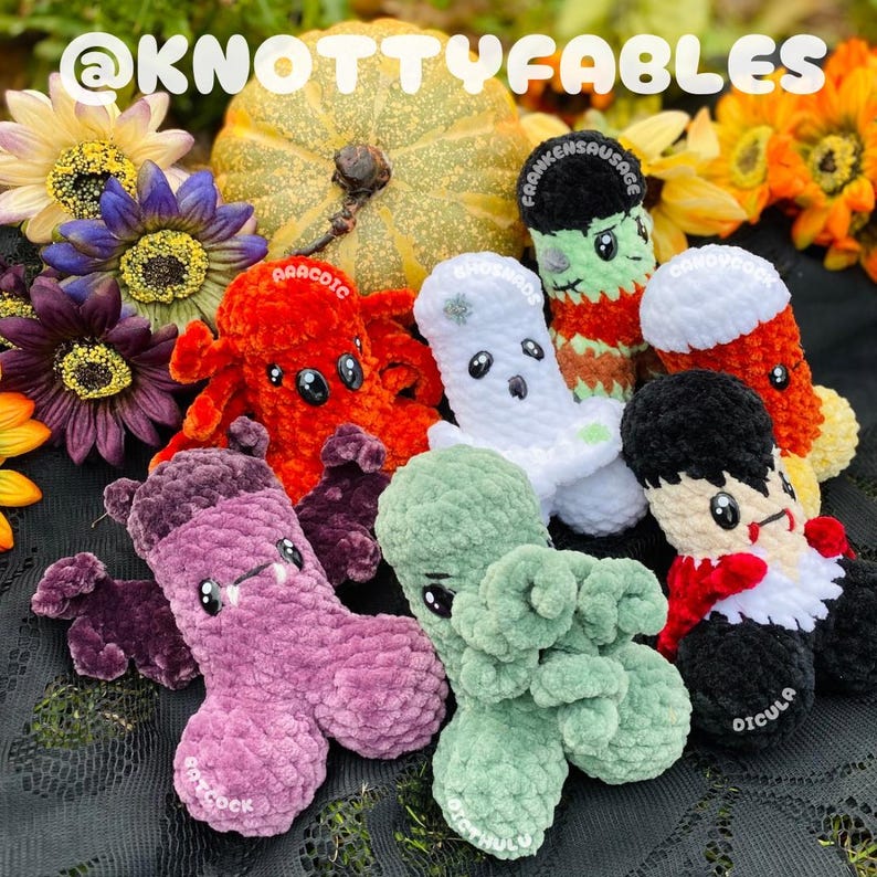 Peut inclure: Une collection de huit peluches en crochet sur le th&egrave;me d'Halloween. Les peluches sont de diff&eacute;rentes couleurs, notamment le vert, le violet, l'orange, le blanc et le noir. Les peluches sont toutes de formes et de tailles diff&eacute;rentes, et elles ont des expressions faciales diff&eacute;rentes. Les peluches sont toutes assises sur une surface noire et blanche. Le texte "@knottyfables" est visible dans le coin sup&eacute;rieur gauche de l'image.