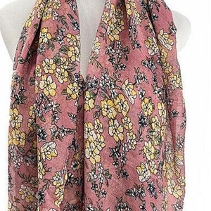 May include: A pink floral scarf with yellow and white flowers. The scarf is made of a soft, lightweight fabric and is perfect for adding a touch of color to any outfit.