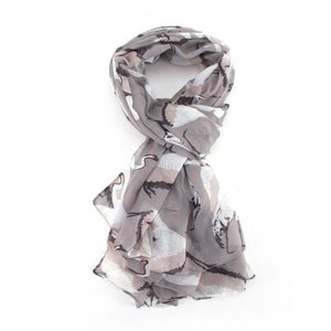 May include: A gray scarf with a white crane print. The scarf is made of a lightweight fabric and is perfect for adding a touch of style to any outfit.