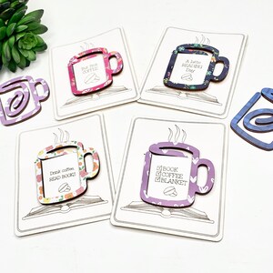 May include: Five different coffee mug shaped bookmarks with various floral and patterned designs. Each bookmark has a different quote about coffee and reading. The bookmarks are on a white background.