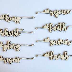 May include: Wooden Easter decorations with bunny silhouettes and words like "king", "christ", "glory", "risen", "rejoice", "faith", "savior", and "lamb".