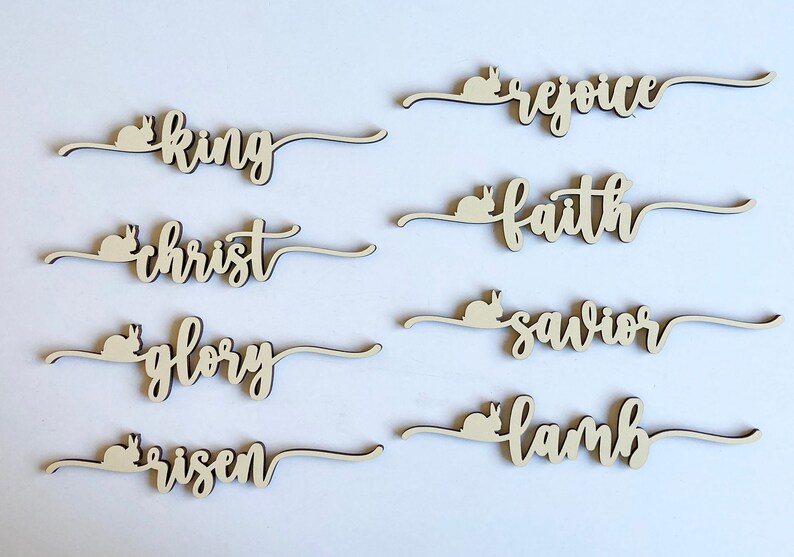 May include: Wooden Easter decorations with bunny silhouettes and words like "king", "christ", "glory", "risen", "rejoice", "faith", "savior", and "lamb".