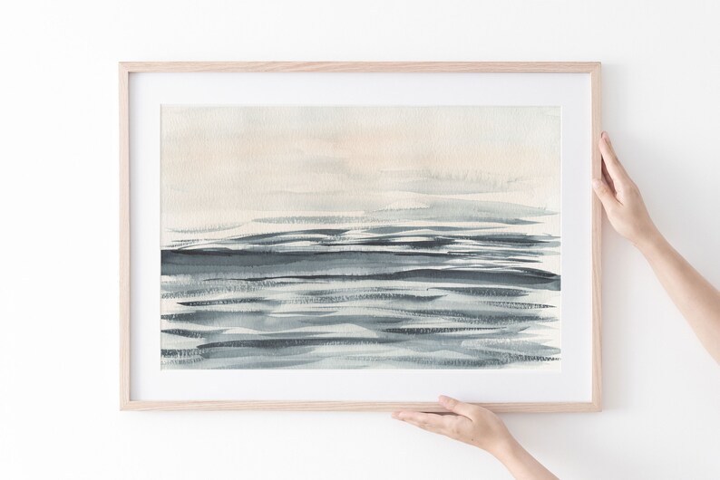 Puede incluir: Una pintura de acuarela enmarcada de un paisaje mar&iacute;timo en una gama de colores azul claro y gris. La pintura representa un horizonte con un cielo azul claro y un mar azul oscuro con pinceladas horizontales.