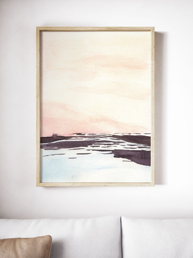 Peut inclure: Une peinture &agrave; l'aquarelle encadr&eacute;e d'un paysage avec un ciel rose et orange, une &eacute;tendue d'eau bleu fonc&eacute; et une masse terrestre gris fonc&eacute; au premier plan.