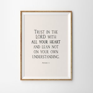 May include: A framed print with a beige background and black text that reads "TRUST IN THE LORD WITH ALL YOUR HEART AND LEAN NOT ON YOUR OWN UNDERSTANDING. PROVERBS 3:5"