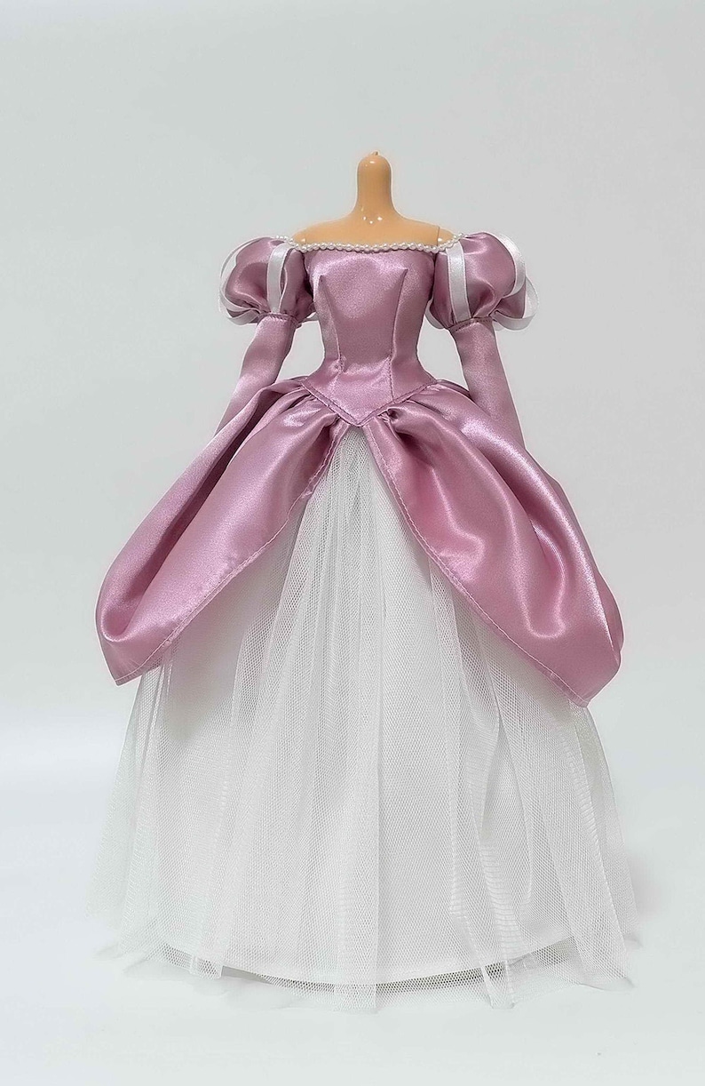 Op de afbeelding: Een roze satijnen baljurk met een witte tule onderrok. De jurk heeft een sweetheart-halslijn en pofmouwen met witte satijnen trim.