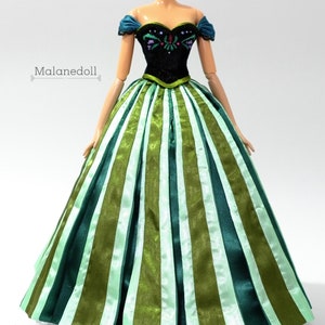 May include: A green and white striped ball gown with a black bodice featuring embroidered details. The bodice has a sweetheart neckline and off-the-shoulder straps.