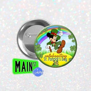 May include: A round button with Mickey Mouse in green, celebrating St. Patrick's Day. The button design includes a rainbow, shamrocks, and the text "celebrating St. Patrick's Day." A green "Main St" sign is also visible.