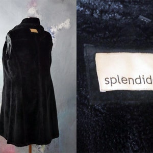 May include: Black faux fur coat with a long, fitted silhouette. The coat has a small label on the back that reads "splendido".