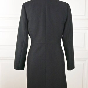 May include: A black long-sleeved blazer with a classic collar and a single-breasted closure. The blazer has a fitted silhouette and a straight hem.