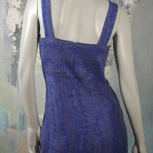 May include: A blue sleeveless dress with a floral pattern. The dress has a square neckline and a zipper in the back.