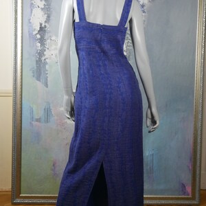 May include: A long, sleeveless, blue dress with a white pattern. The dress has a square neckline and a slit up the back.