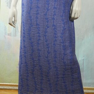 May include: A long, blue skirt with a floral pattern. The skirt is made of a textured fabric and has a simple, elegant design.