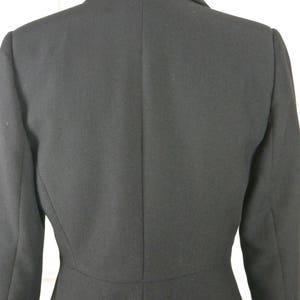May include: A black blazer with a classic design. The blazer has a single-breasted closure and a notched lapel.