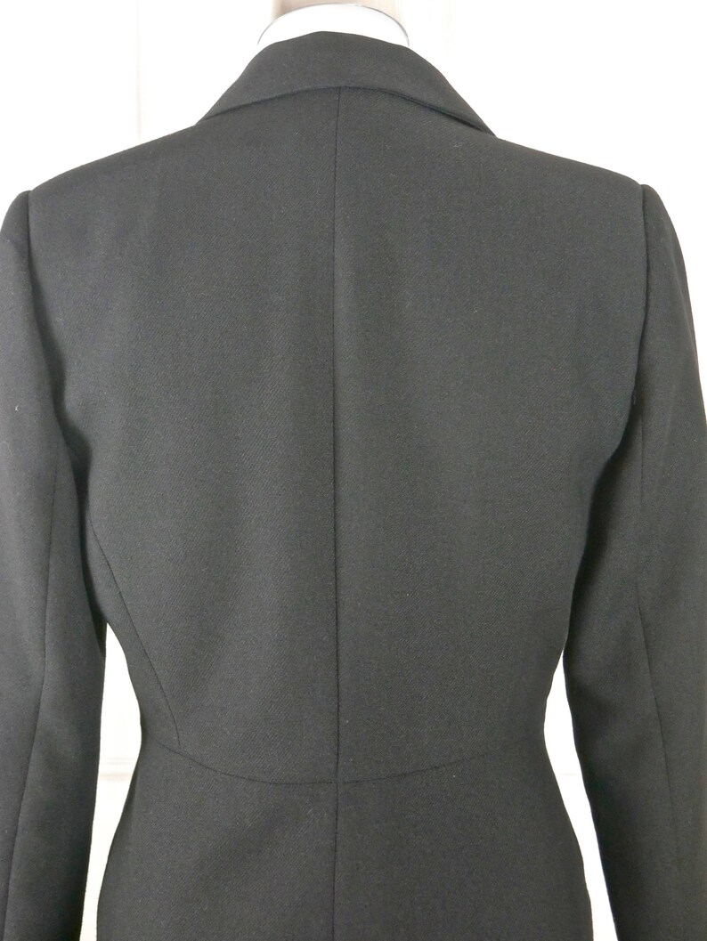 May include: A black blazer with a classic design. The blazer has a single-breasted closure and a notched lapel.