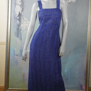 May include: A long, blue, sleeveless dress with a square neckline and a subtle pattern. The dress is made of a lightweight fabric and has a relaxed fit.