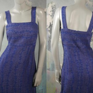 May include: A sleeveless blue dress with a white floral pattern. The dress has a square neckline and a fitted bodice.