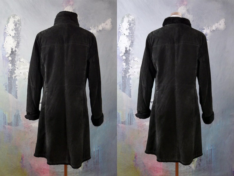 May include: A black suede jacket with a faux fur collar and cuffs. The jacket has a long, A-line silhouette and a zipper closure.