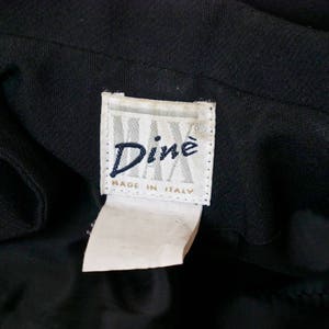 May include: A black garment with a white label that reads "Din&eacute; Made in Italy".