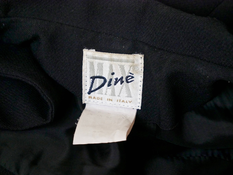 May include: A black garment with a white label that reads "Din&eacute; Made in Italy".
