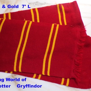 May include: A scarlet and gold scarf, approximately 7 feet long, with yellow stripes. The scarf has a fringed edge and the text "Scarlet & Gold" and "Gryffindor" is visible.