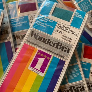 May include: Packages of WonderBra pantyhose in various colors. The packaging includes the text "Sheer, Plain Knit Sandalfoot" and "Fits 5' - 5'8", 100-150 lbs". The packaging has a rainbow stripe design.