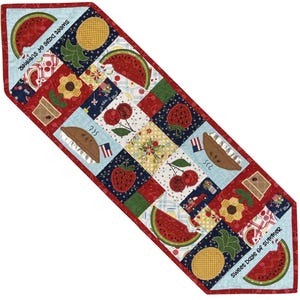 Puede incluir: Camino de mesa acolchado con un diseño de patchwork con frutas de verano y motivos florales. El camino incluye imágenes de sandías, piñas, cerezas y fresas. El texto "Sweet Days of Summer" está impreso en el borde azul claro.