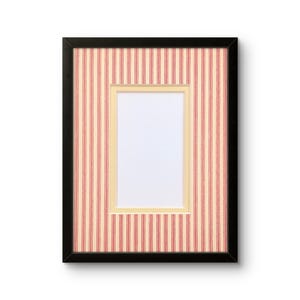 May include: Black rectangular picture frame with a red and cream striped background and a cream-colored mat. The frame has a white interior space for a photo or artwork.