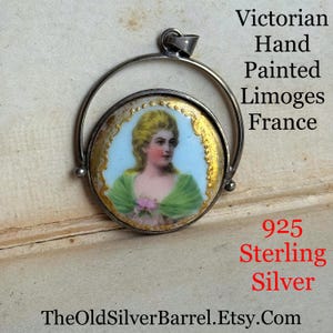 May include: A silver swivel pendant with a hand-painted Limoges porcelain cameo featuring a woman in a green dress. The pendant is marked "925 Sterling Silver" and "TheOldSilverBarrel.Etsy.com".