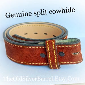 May include: A brown leather belt with yellow stitching and a dark brown suede finish. The belt is labeled "Genuine split cowhide".
