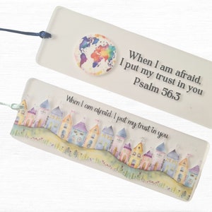 May include: Two glass bookmarks with a religious theme. The top bookmark features a watercolor globe with the text "When I am afraid, I put my trust in you Psalm 56:3". The bottom bookmark features a watercolor illustration of a row of colorful houses with the text "When I am afraid, I put my trust in you".