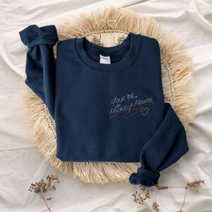 Puede incluir: Una sudadera azul marino con el texto "Your pal Mickey Mouse" en escritura blanca con una l&iacute;nea roja debajo y una cabeza de Mickey Mouse amarilla.