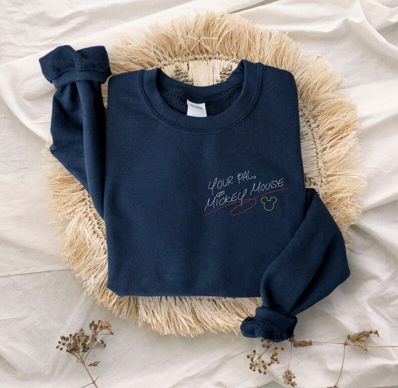 Puede incluir: Una sudadera azul marino con el texto "Your pal Mickey Mouse" en escritura blanca con una l&iacute;nea roja debajo y una cabeza de Mickey Mouse amarilla.