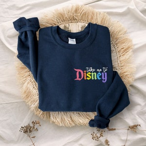 May include: Navy blue sweatshirt with a rainbow coloured "Take me to Disney" graphic on the front.