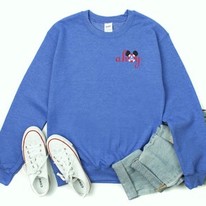 May include: A blue sweatshirt with a red and white Mickey Mouse head and the word "ahoy" in red cursive lettering.