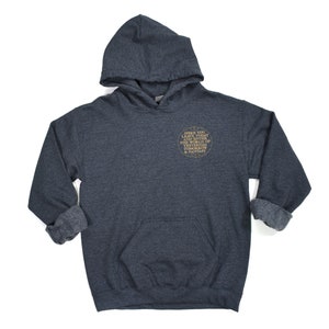 May include: A dark gray hooded sweatshirt with a gold circle graphic on the front. The graphic says "Before you leave today and enter the world of tomorrow, bring a story & fantasy."