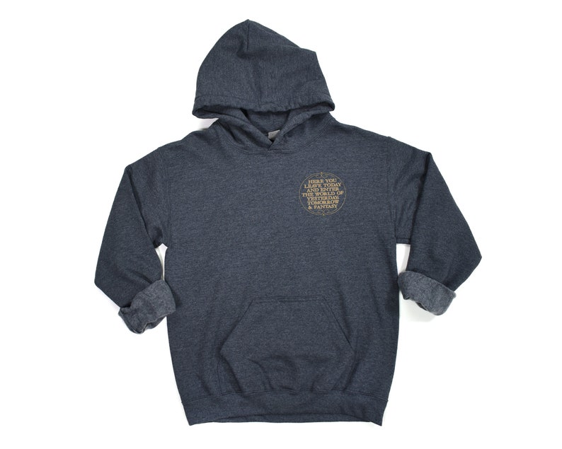 May include: A dark gray hooded sweatshirt with a gold circle graphic on the front. The graphic says "Before you leave today and enter the world of tomorrow, bring a story & fantasy."