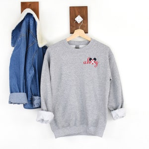 May include: Gray sweatshirt with a red and black Mickey Mouse ears design and the text "ah-hoy" in red.