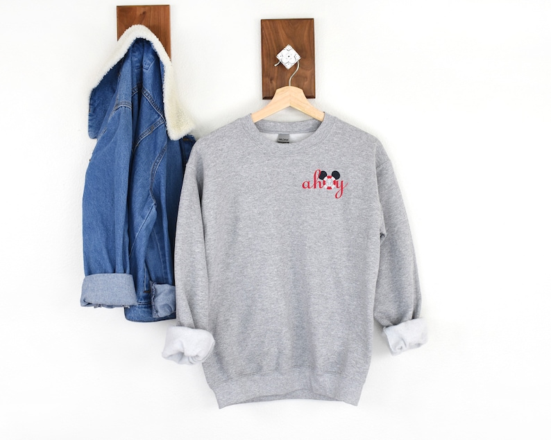 May include: Gray sweatshirt with a red and black Mickey Mouse ears design and the text "ah-hoy" in red.