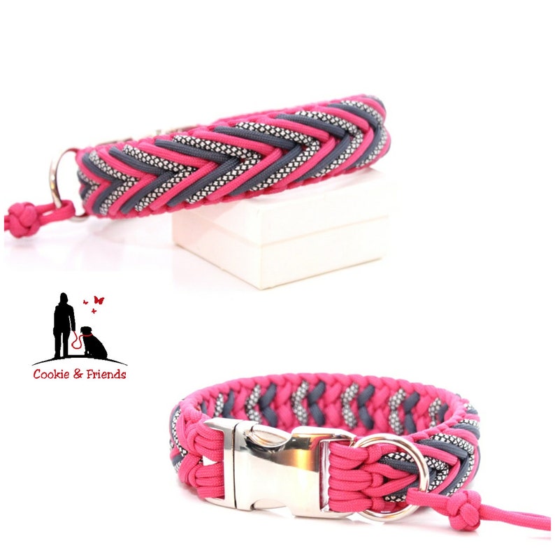 May include: A pink and gray braided dog collar with a silver buckle. The collar is made of paracord and has a silver D-ring. The collar is shown on a white background.