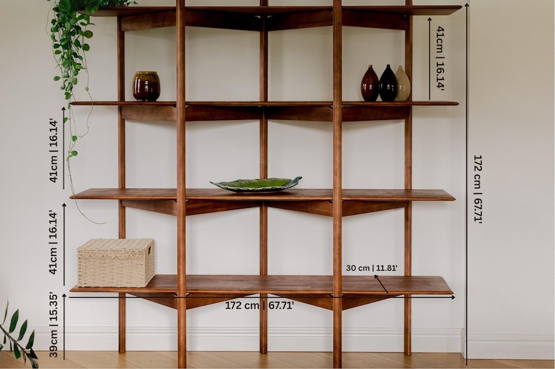May include: A mid-century modern wooden shelving unit with multiple shelves. The unit is 67.71 inches wide and 67.71 inches tall. The shelves are 11.81 inches deep. The unit is holding decorative items.