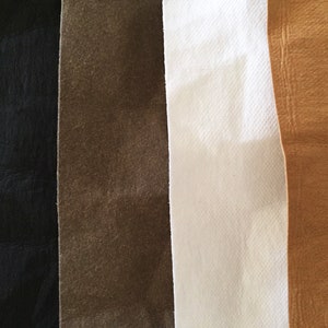 May include: Four fabric swatches in different colors: black, brown, white, and tan.