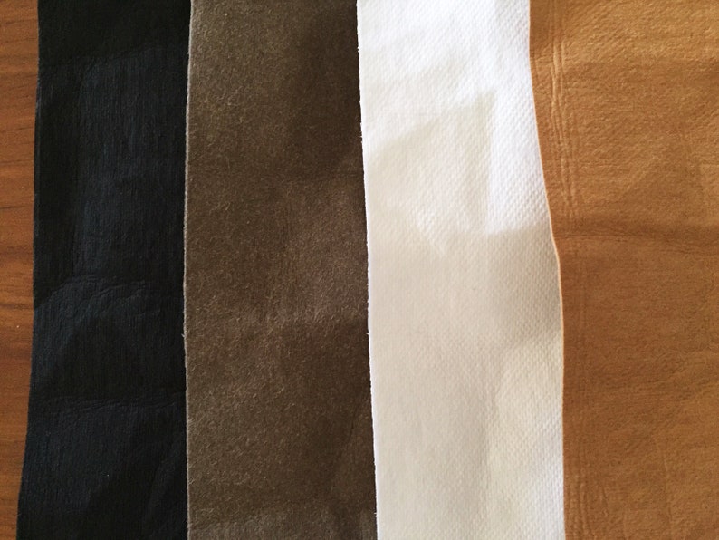 May include: Four fabric swatches in different colors: black, brown, white, and tan.